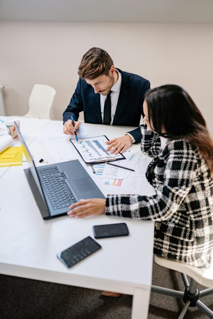 Business professionals analyzing data and collaborating on a project in a modern office setting.